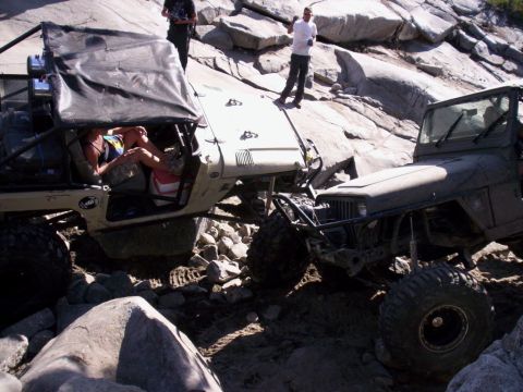 1989 Ford Bronco - Two off-road vehicles tackle a challenging rocky path, demonstrating their off-road capabilities.