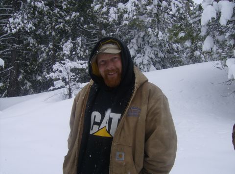 1986 Ford Bronco - Man in winter clothing smiles in a snowy forest scene.