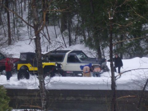 1986 Ford Bronco - Two people mooning next to a 1986 Ford Bronco and a yellow Jeep in a snowy scene.