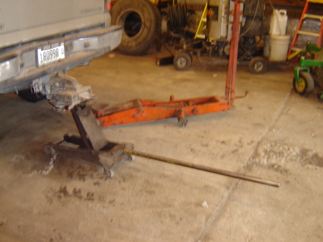 Rear of a vehicle on jacks in a garage with tools and equipment around