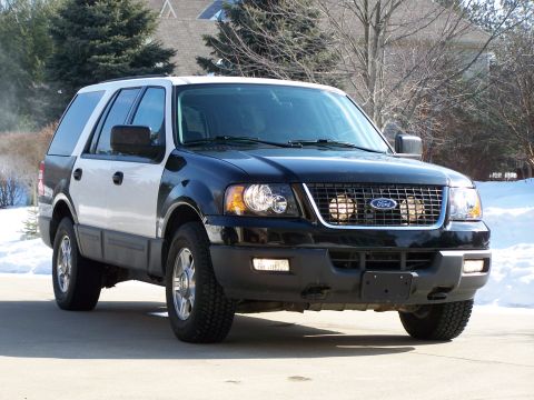 2004 Ford Expedition - A two-tone Ford Expedition SUV is shown from the front three-quarter view, equipped with auxiliary driving lights.