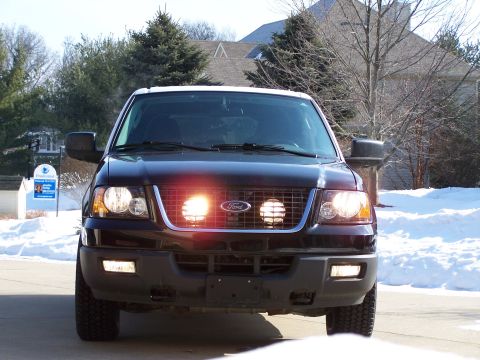 2004 Ford Expedition - Front view of a black 2004 Ford Expedition, auxiliary driving lights illuminated.