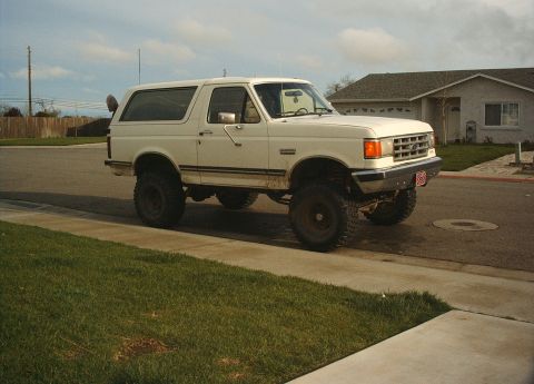 1987 Ford Bronco - This lifted 1987 Ford Bronco is parked on the side of a suburban street.
