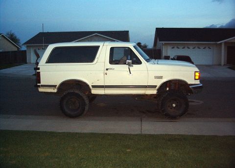 1987 Ford Bronco - This lifted 1980s Ford Bronco has a body lift and oversized tires, suggesting off-road modifications.