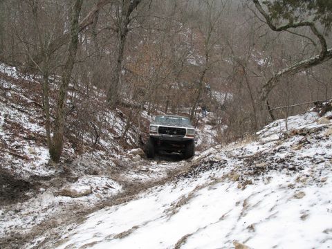 1995 Ford Bronco - 1995 Ford Bronco tackling a challenging off-road course in snowy and muddy conditions.