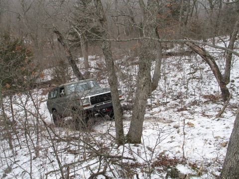 1995 Ford Bronco - A Ford Bronco navigates a snowy, wooded terrain during winter.