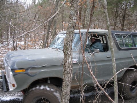 1995 Ford Bronco - Ford Bronco navigates a muddy trail in a wooded area during winter.