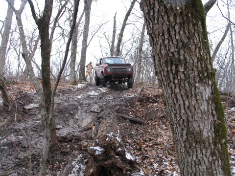 1995 Ford Bronco - Off-road vehicle struggles on a difficult, muddy trail during winter.