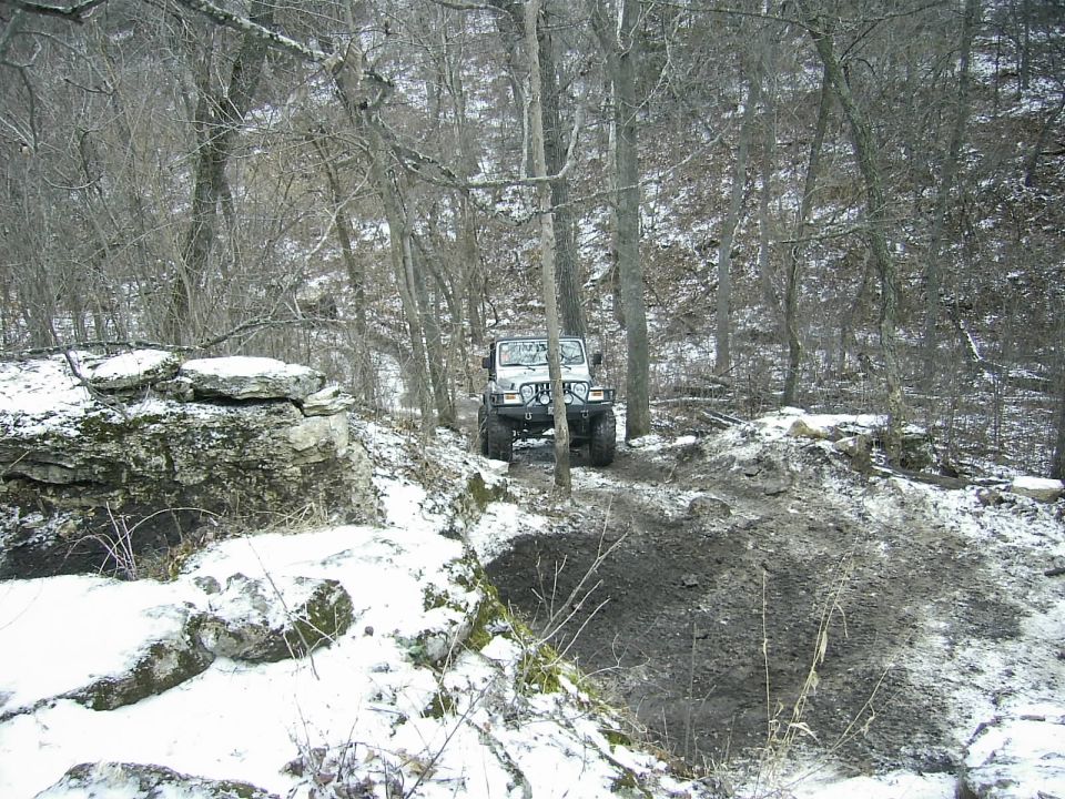 White Jeep Wrangler on snowy trail in woods
