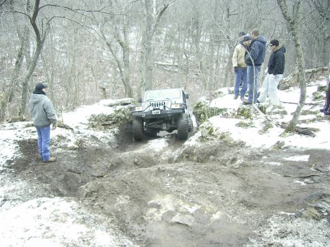 1978 Ford Bronco - A Jeep Wrangler tackles a challenging off-road course in a snowy, wooded environment.
