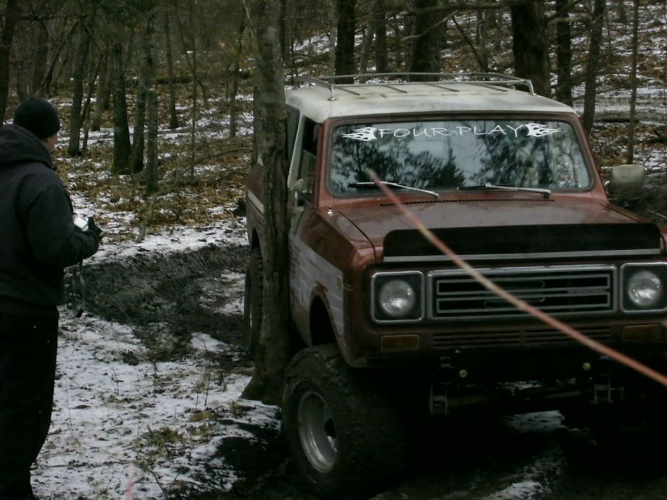 Brown International Harvester Scout II with white roof stuck in mud, front view