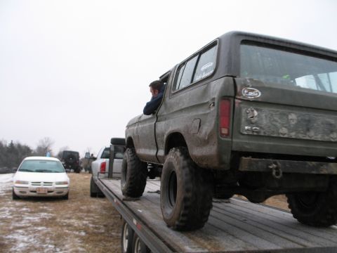 1995 Ford Bronco - This lifted 1978 Ford Bronco is being transported on a trailer, with other vehicles visible in the background.