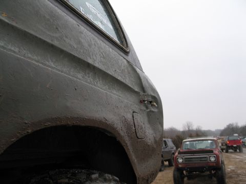 1995 Ford Bronco - Several off-road vehicles are parked in a field under an overcast sky.