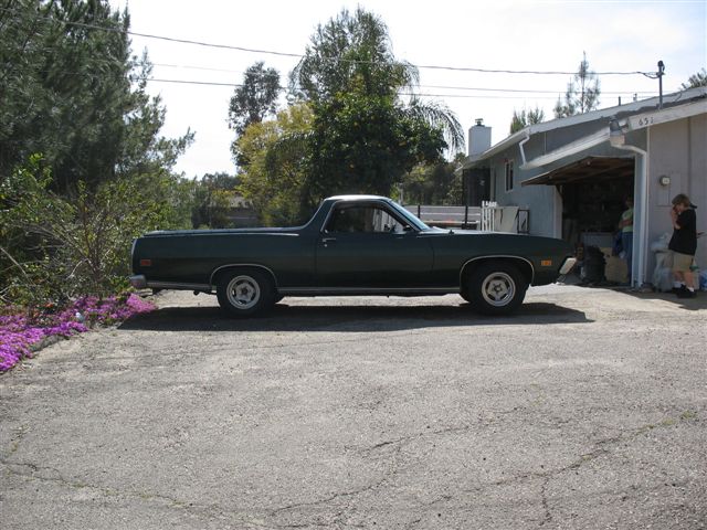 Dark green Ford Ranchero car-pickup side profile in a driveway