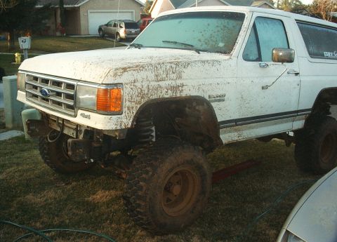 1987 Ford Bronco - This 1987 Ford Bronco is heavily splattered with mud, showing its lifted suspension and off-road tires.