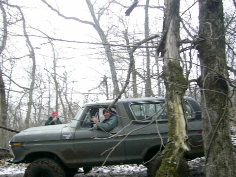 1978 Ford Bronco - This 1978 Ford Bronco navigates a wooded trail with a driver and passenger visible.