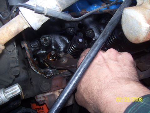 1978 Ford Bronco - A hand works on an engine's valve spring and rocker arm assembly, with a date stamp of 02/23/2008 visible.