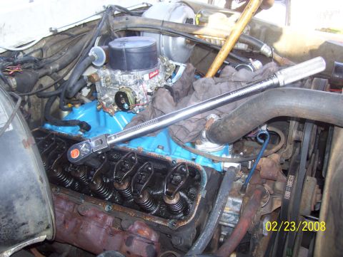 1978 Ford Bronco - Close-up view of an engine bay, showing internal engine components and a torque wrench.