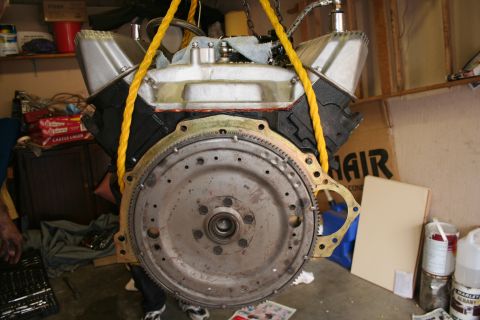 1969 Ford Fairlane - An engine block is suspended by yellow ropes, with its flywheel visible.