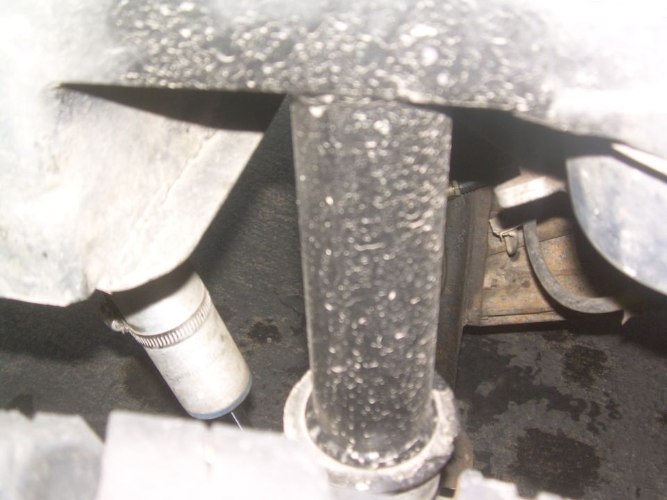 close-up of suspension parts, possibly a shock absorber and hose clamp