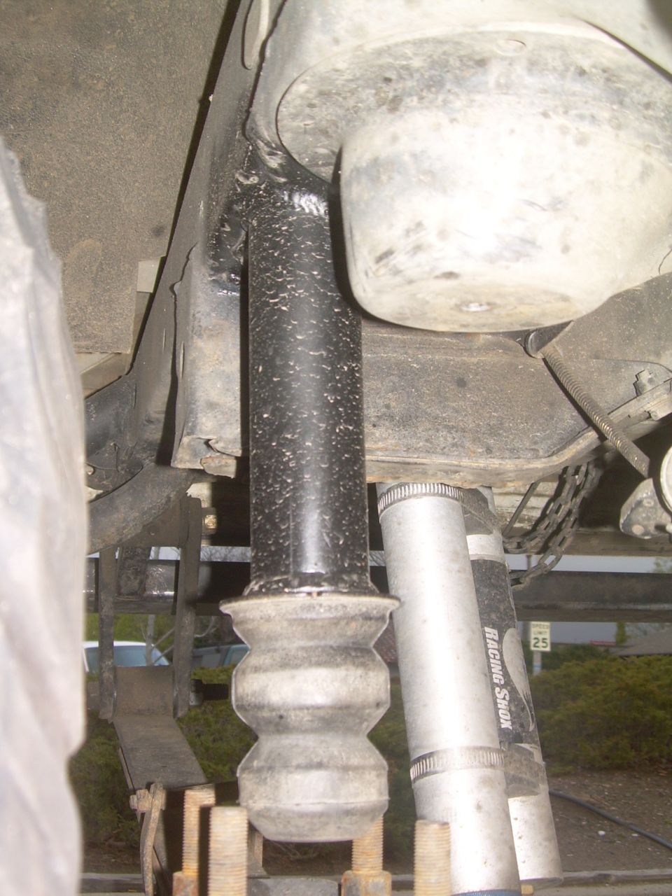 Black shock absorber with rubber bump stop above silver shock absorber labeled Racing Shock