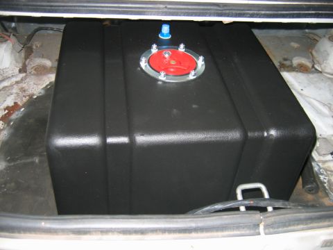 1992 Ford Mustang - A black aftermarket fuel cell with a red cap is installed in the trunk of a car.
