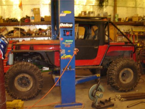 1992 Ford Bronco - This modified off-road vehicle, possibly a Jeep, is shown on a lift in a workshop setting.