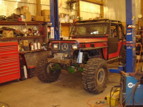 1992 Ford Bronco - Custom off-road vehicle in a garage, large tires and a Mercedes-Benz grille emblem.