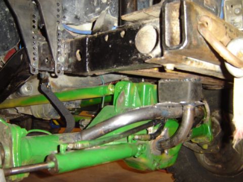 1992 Ford Bronco - The underside of a vehicle shows heavy modifications to its suspension system, painted bright green.