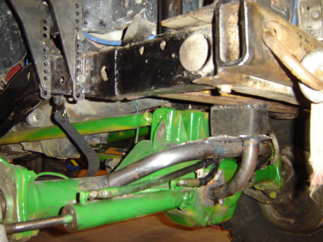 close-up of green-painted suspension components and black frame of a modified vehicle