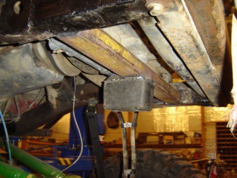 1992 Ford Bronco - Close-up view of the rusty undercarriage of a vehicle, showing suspension components and frame.