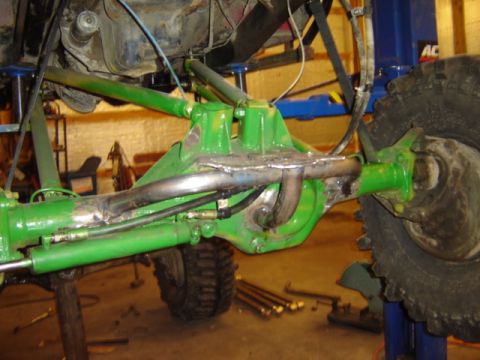 1992 Ford Bronco - Customized rear axle assembly with hydraulic components and a large off-road tire visible.