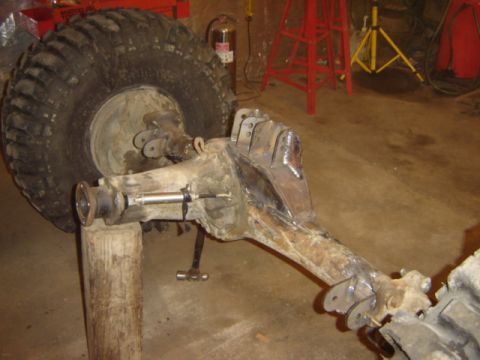 1992 Ford Bronco - A heavy-duty axle assembly with a large tire is shown, likely undergoing modification or repair in a garage setting.
