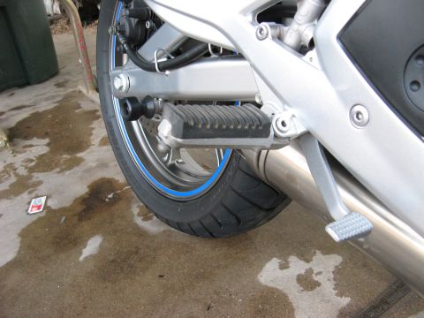 2007 Kawasaki Ninja - Close-up view of a motorcycle's rear wheel, tire, and footpeg assembly.