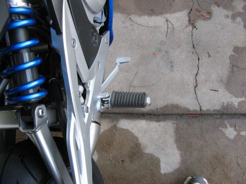 2007 Kawasaki Ninja - A detailed view of a motorcycle's rear suspension and footpeg assembly, focusing on mechanical components.