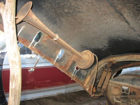 1952 Ford Panel Van - A close-up shot of a vintage horn assembly, showing significant rust and wear within the vehicle's interior.