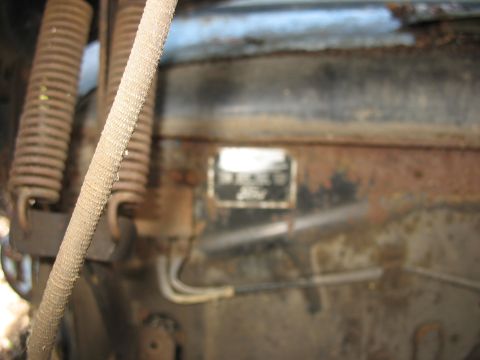 1952 Ford Panel Van - Data plate on a rusty engine bay, showing springs and wiring.