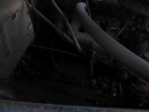 1952 Ford Panel Van - The engine bay of a vehicle shows various mechanical components and hoses.