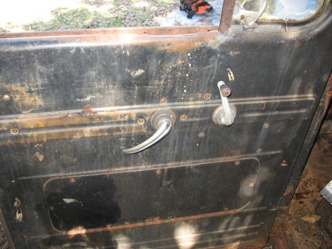 1952 Ford Panel Van - Interior door panel showing chrome door handle and window crank, with visible rust.