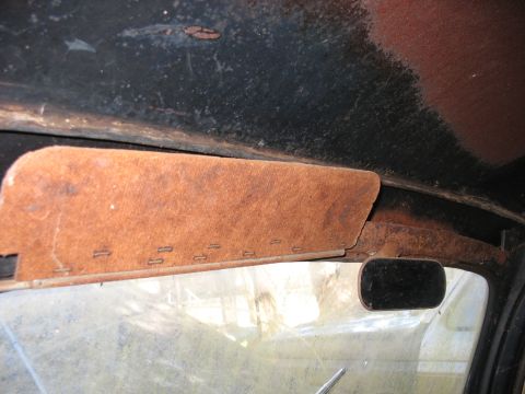1952 Ford Panel Van - The interior of a vehicle is shown, focusing on the sun visor and rearview mirror, with visible signs of wear and rust.