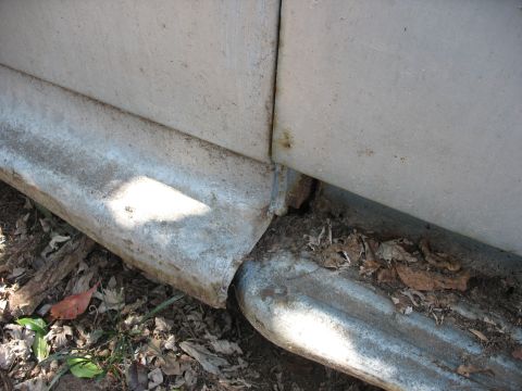 1952 Ford Panel Van - Detail of a vehicle's lower body and running board, with debris on the ground.