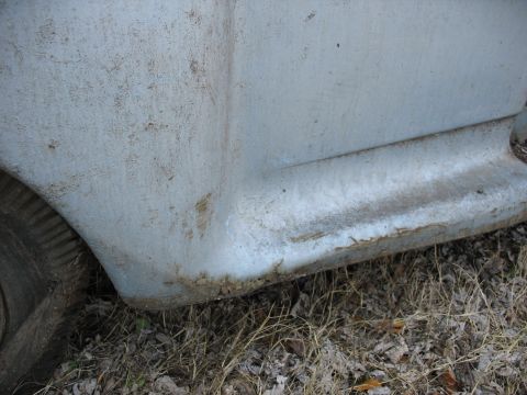 1952 Ford Panel Van - Close-up view of the fender and lower body of a light blue 1952 Ford Panel Van, showing signs of age and wear.