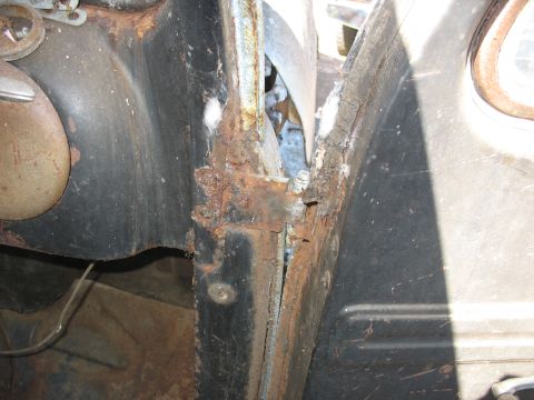 1952 Ford Panel Van - Close-up view of significant rust damage on the door frame and surrounding metal of an old vehicle.