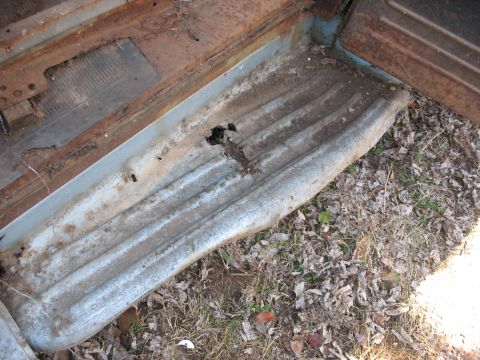 1952 Ford Panel Van - Close-up of a heavily rusted interior step and floor panel of an old vehicle.