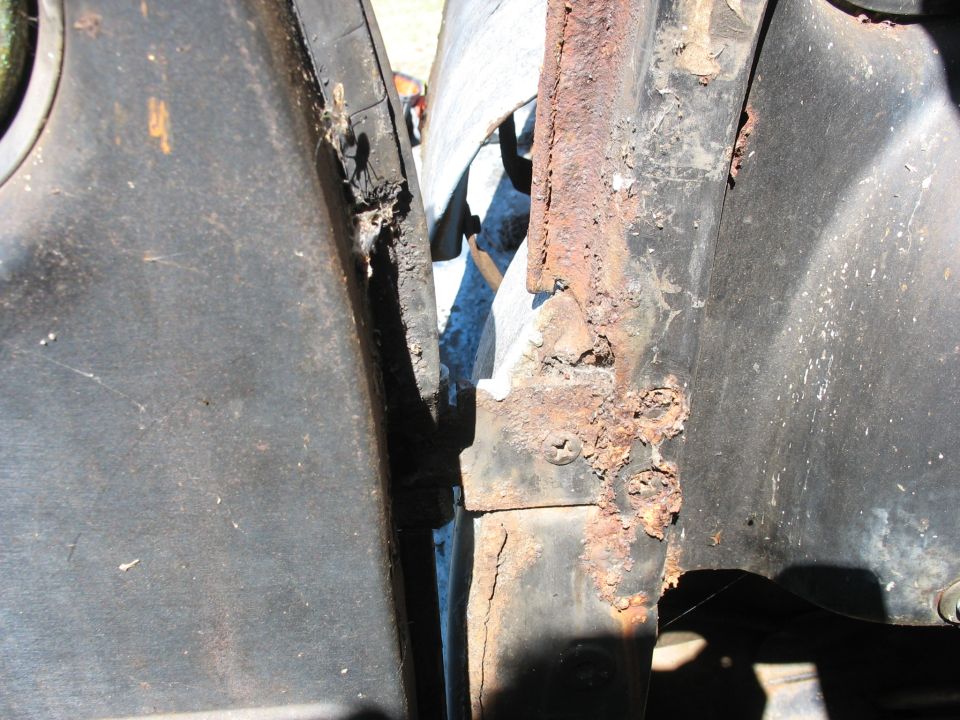 Rusted door jamb and pillar with flaking black paint on vintage vehicle