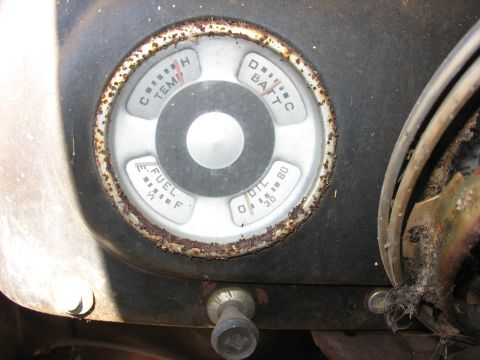 1952 Ford Panel Van - Close-up of a vintage truck dashboard's round four-in-one cluster gauge with TEMP, BATT, FUEL and OIL quadrants on a white face, ringed by…