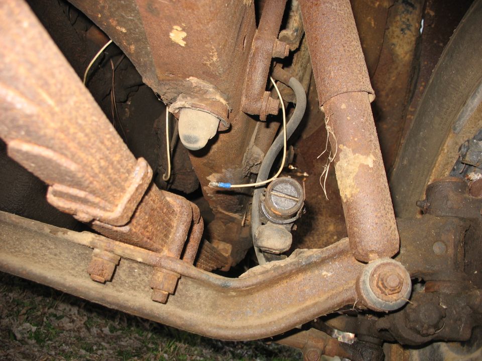 Heavily rusted vehicle suspension and steering components with frayed wiring