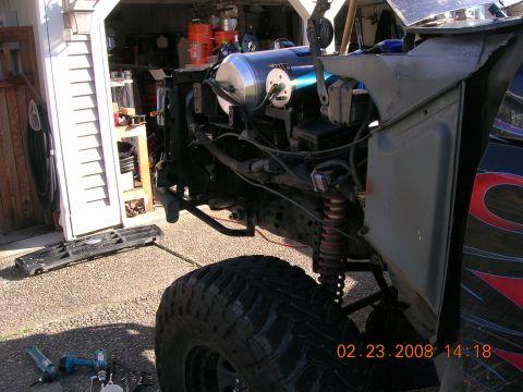 1996 Ford Bronco - The front end of a vehicle is disassembled, revealing the engine and suspension parts.