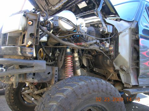 1996 Ford Bronco - The front of a truck is disassembled, revealing its engine and suspension components.