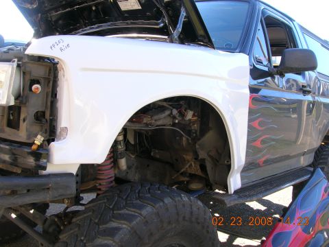 1996 Ford Bronco - White fiberglass fender with "FF203 Rice" written on it, attached to a black SUV with flame decals.